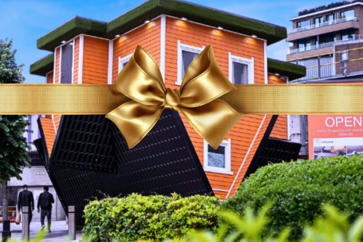 Upside-down orange house with a gold ribbon and bow across the image.