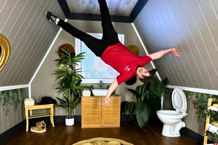 Person in a red shirt hanging sideways in a slanted room.